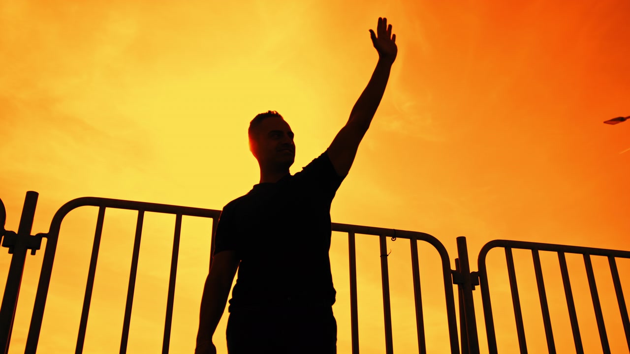 Silhouette di un uomo che saluta con il braccio