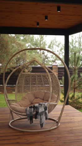 relaxing outdoor hanging egg chair on a wooden deck