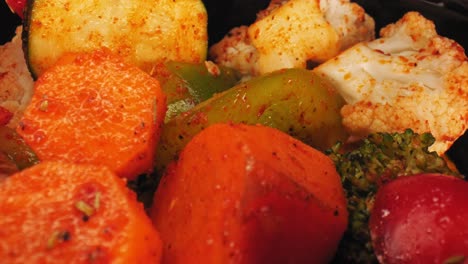 cinematic close-up macro pan of grilled vegetables medley including cauliflower, carrots, green bell peppers and zucchini