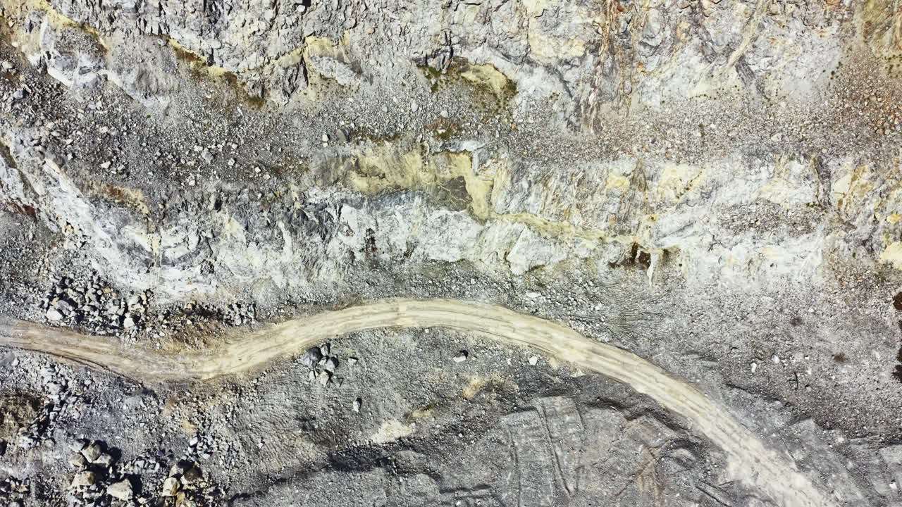 Granitbrud viser arbejdere, der skærer sten fra jorden i en mineoperation om dagen på et fjerntliggende sted.