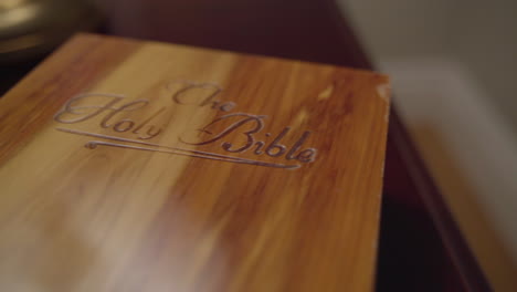 close up dolly across wooden book box labeled the holy bible