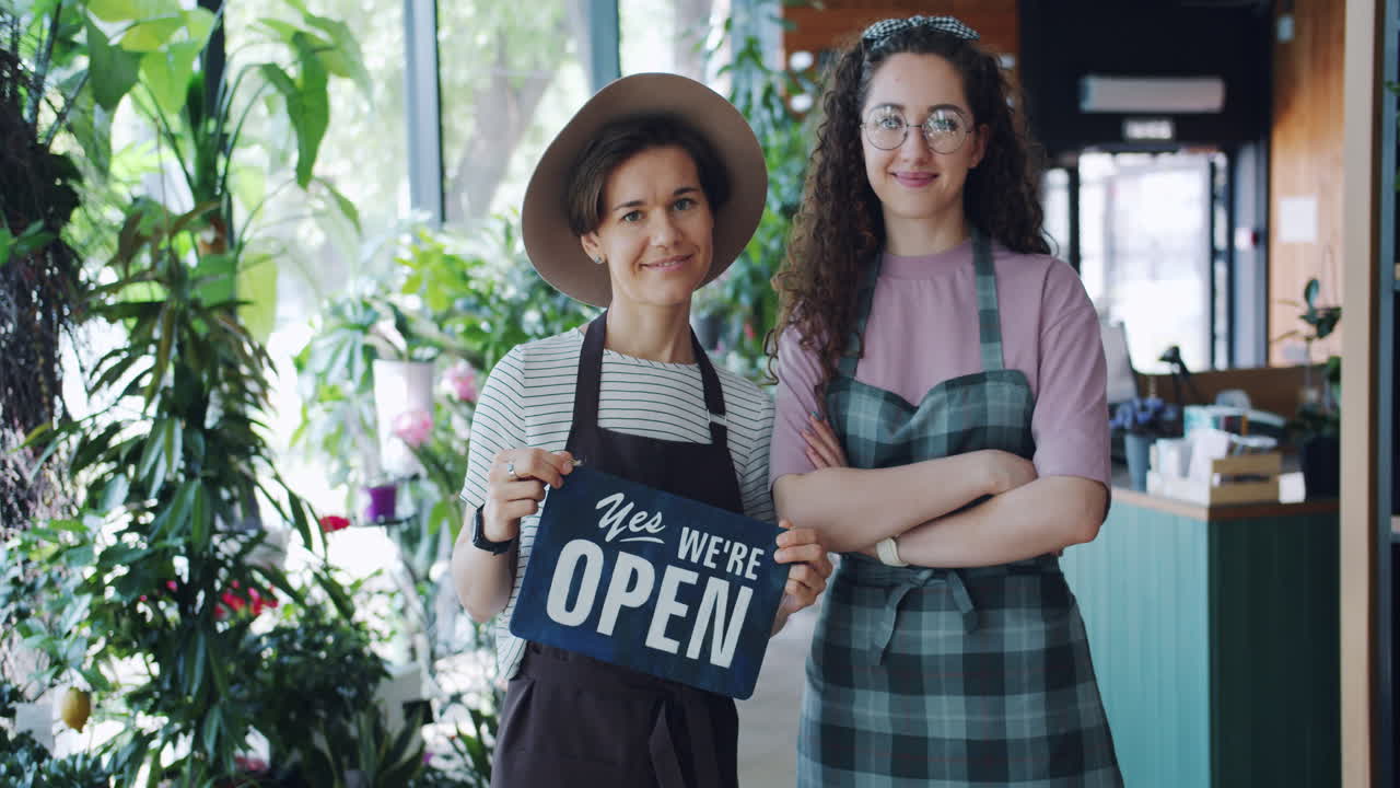 Two Women at a Floral Shop Displaying Open Sign