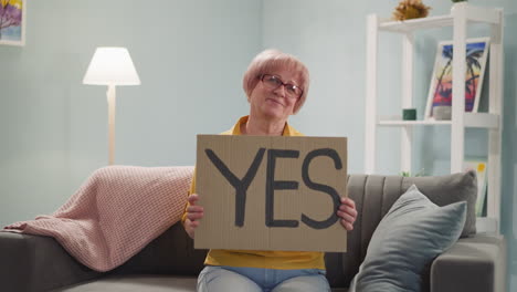 elderly woman picks up poster with inscription