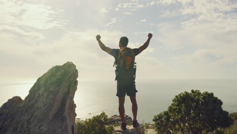 un joven excursionista de montaña celebrando la escalada al pico