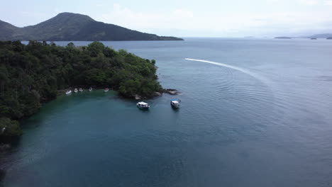 Aerial-view-towards-tour-boats-on-the-coastline-of-cloudy-Costa-Verde,-Brazil