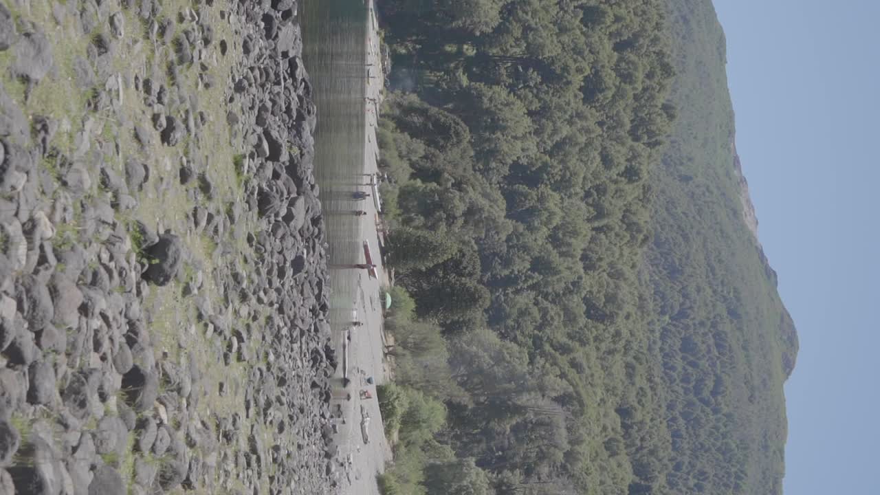 아르헨티나 파타고니아의 산과 숲이 있는 해안에서 휴식을 취하는 사람들이 있는 고요한 호수