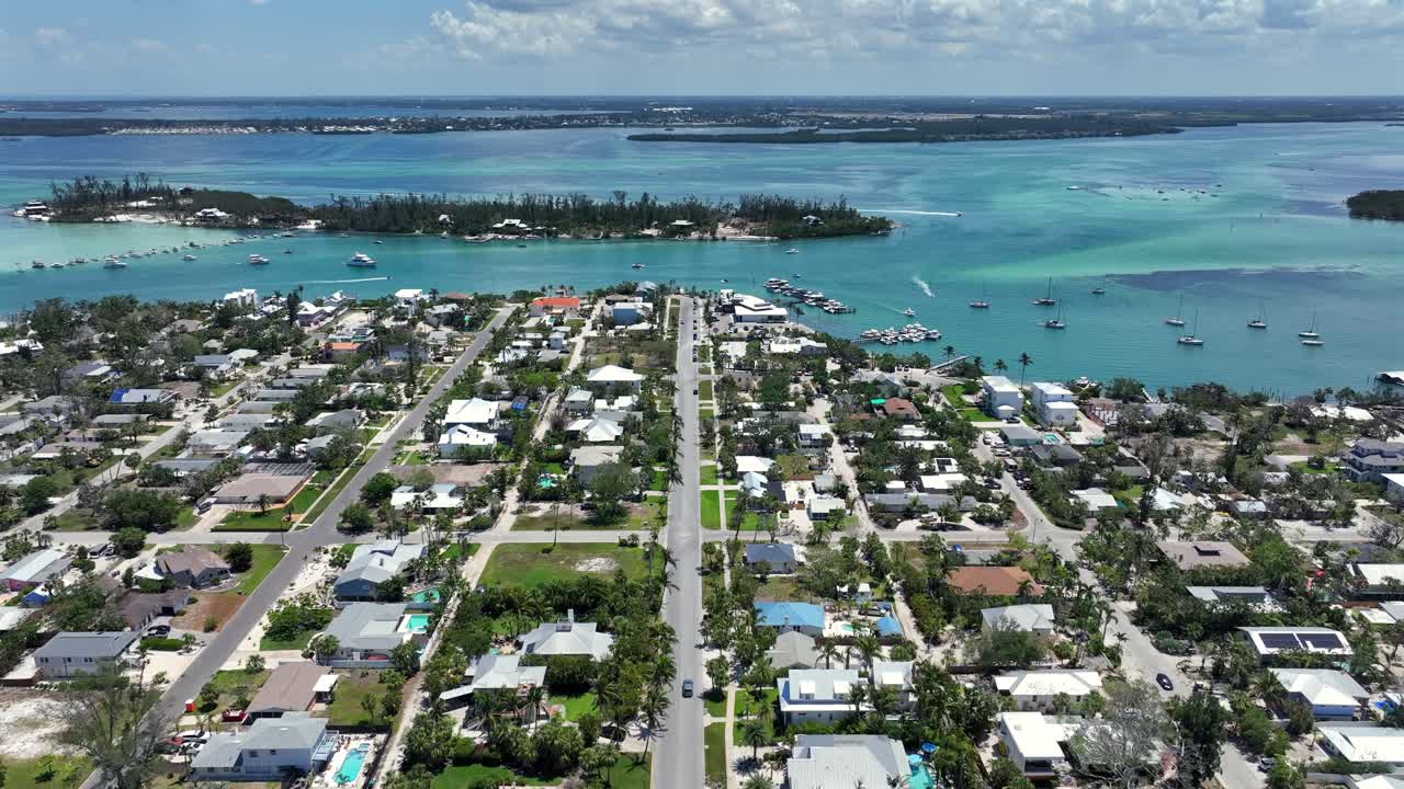 Aerial establishing shot of luxury small city of coquina beach with boats on sea in summer. Florida state in USA. Luxury houses and homes with gulf view. Wide shot.