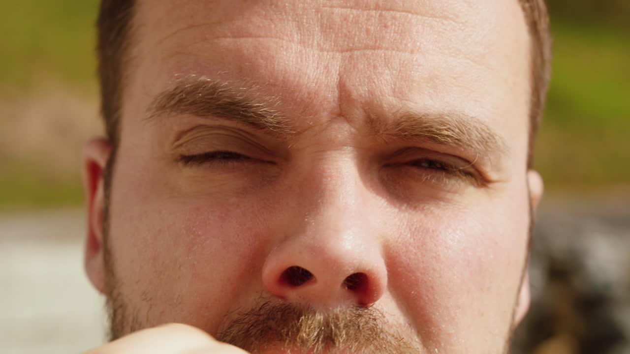 Close-up de um homem esfregando os olhos devido à irritação causada por alergia a pólen. Conceito de alergias sazonais, olhos com coceira, sintomas de febre do feno e reações alérgicas