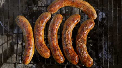 Delicious-juicy-sausages,-cooked-on-the-grill-with-a-fire.