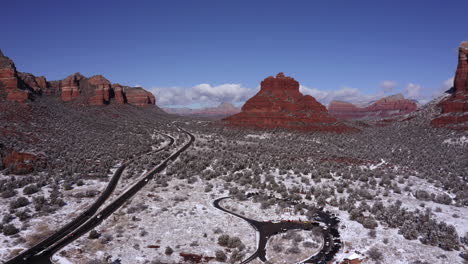 aerial pan of bell rock and courthouse butte and castle rock, sedona arizona - after a snowfall