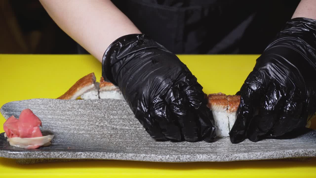 el chef preparando rollos de sushi unagi