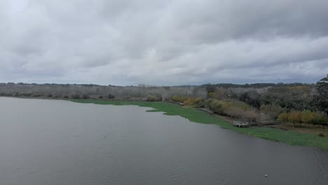 aerial view of a large lake shore on a cloudy autumn day