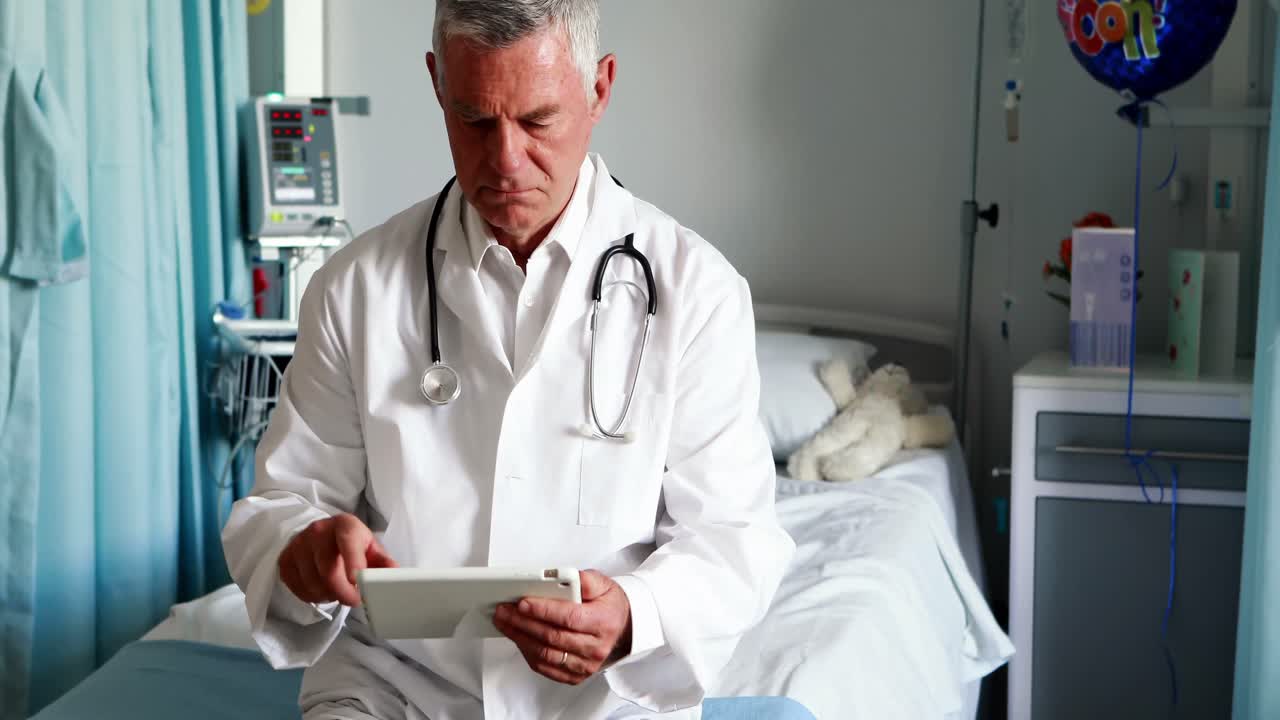 Medico maschio che utilizza compressa digitale nel reparto