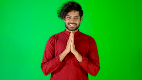 indian guy namaste with green screen - green background - chroma key