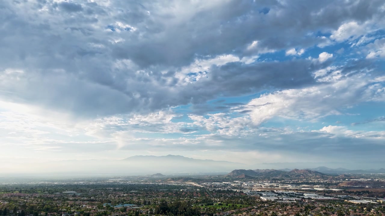 En betagende udsigt over den sydcaliforniske himmel. Dronen svæver ubevægeligt, mens skyerne bevæger sig væk fra kameraet mod vest i et filmisk syn at skue.
