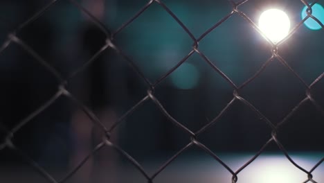 night view of a chain link fence at a sports facility