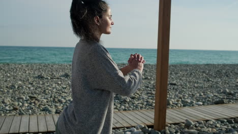 woman practicing yoga on a beach