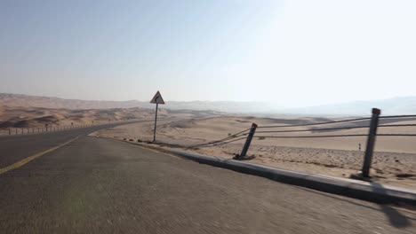 car drives through amazing sand dunes of abu dhabi desert with camera side mounted