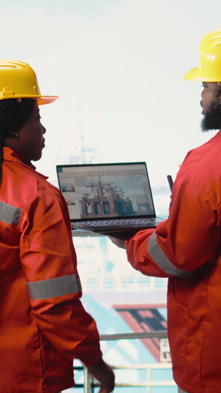 Vertical video Offshore platform employees use management software to observe operations