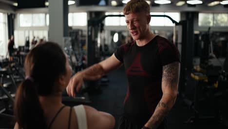 a personal trainer talking to a client at the gym