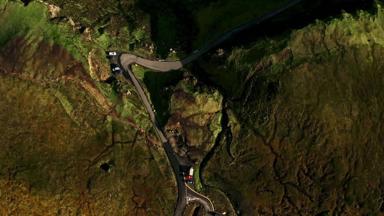 Winding Road And Parking Area In Rugged Terrain Of Quiraing On Isle Of Skye, Scotland, UK. aerial topdown shot