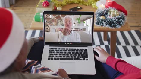 Madre-E-Hija-Afroamericanas-Usando-Una-Computadora-Portátil-Para-Una-Videollamada-Navideña-Con-Una-Mujer-En-La-Pantalla