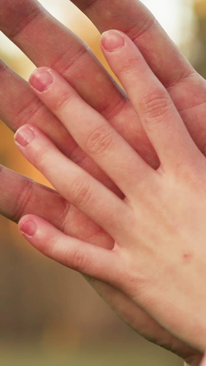 una toma de primer plano de una mano adulta puesta suavemente en la mano de un niño, simbolizando cuidado, protección y conexión. la imagen captura un tierno momento de calor y afecto