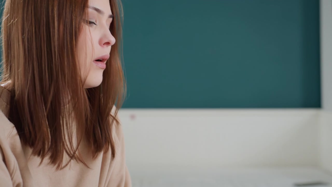 White woman closeup study reflection in quiet bedroom, teal wall and headboard backdrop, pensive student revising grammar notes and homework, subtle shadow and soft light emphasize thoughtful