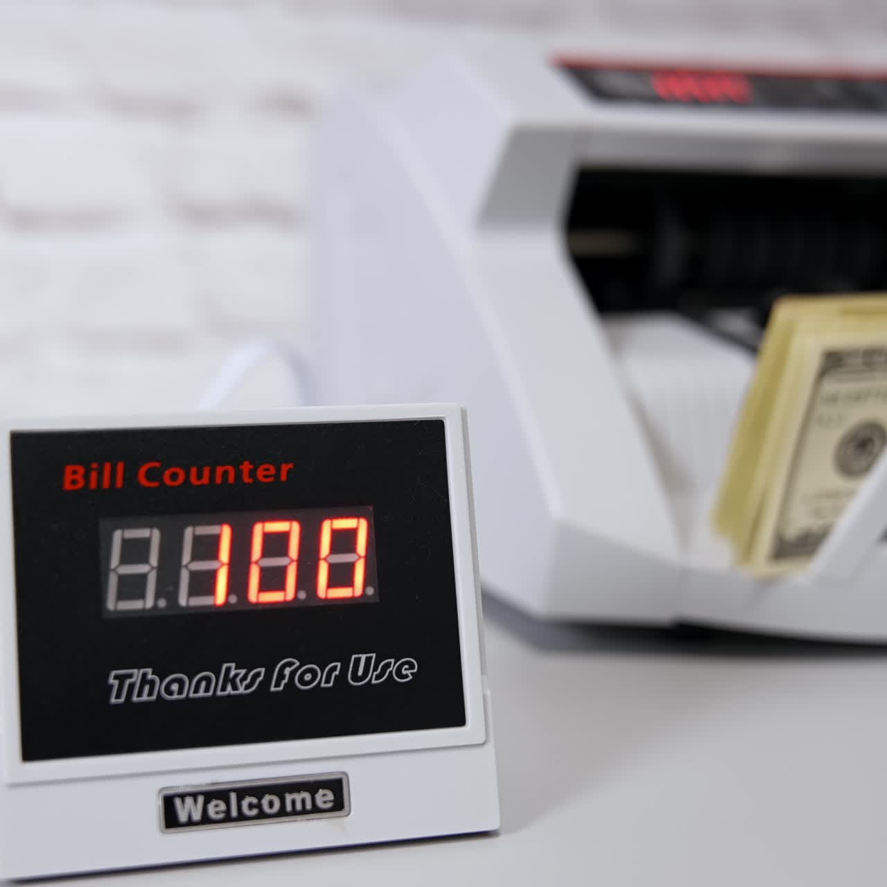 US Dollar bills. Woman putting money into counting machine at table indoors, close up