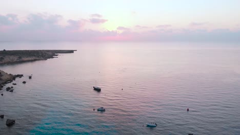 aerial panning shot over boats anchored in konnos bay at dusk