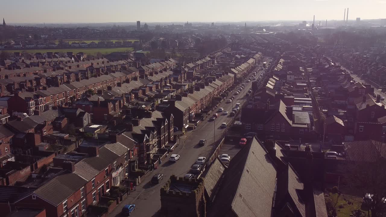 la vista aérea desciende a hileras de históricas casas adosadas en dentons green, st helens, con un largo camino que conduce hacia el bullicioso centro de la ciudad
