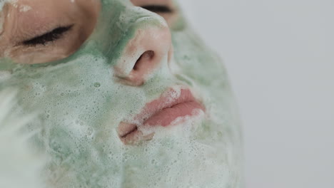 mujer aplicando mascarilla facial