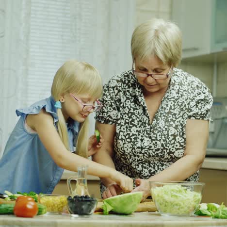 Divertida-Niña-De-6-Años-Ayuda-A-Su-Abuela-A-Preparar-Comidas-En-La-Cocina-3