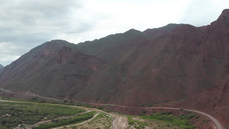 aerial - highway and mountains, cafayate, argentina, wide lowering shot