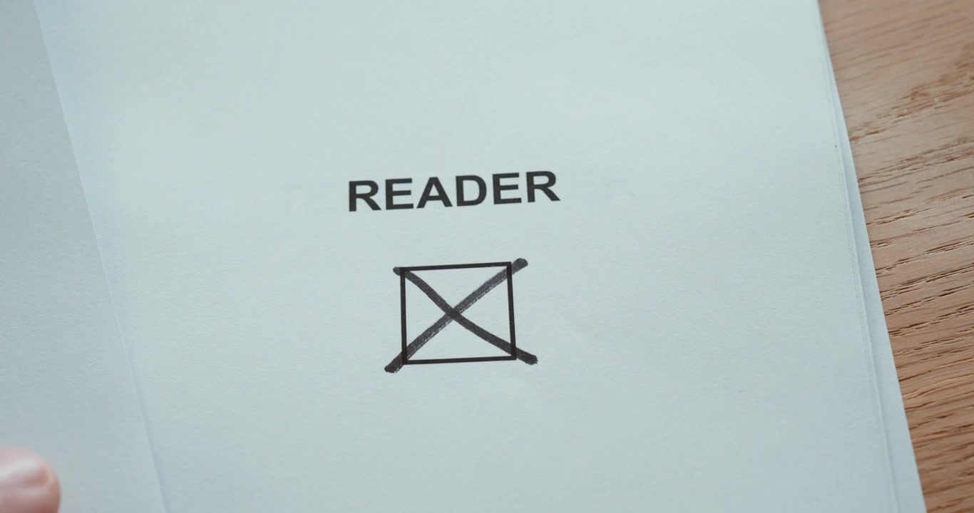 Close-up of a hand marking the reader checkbox on a paper form, representing reading habits, books and personal interests.