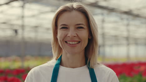 smiling woman working in a flower greenhouse