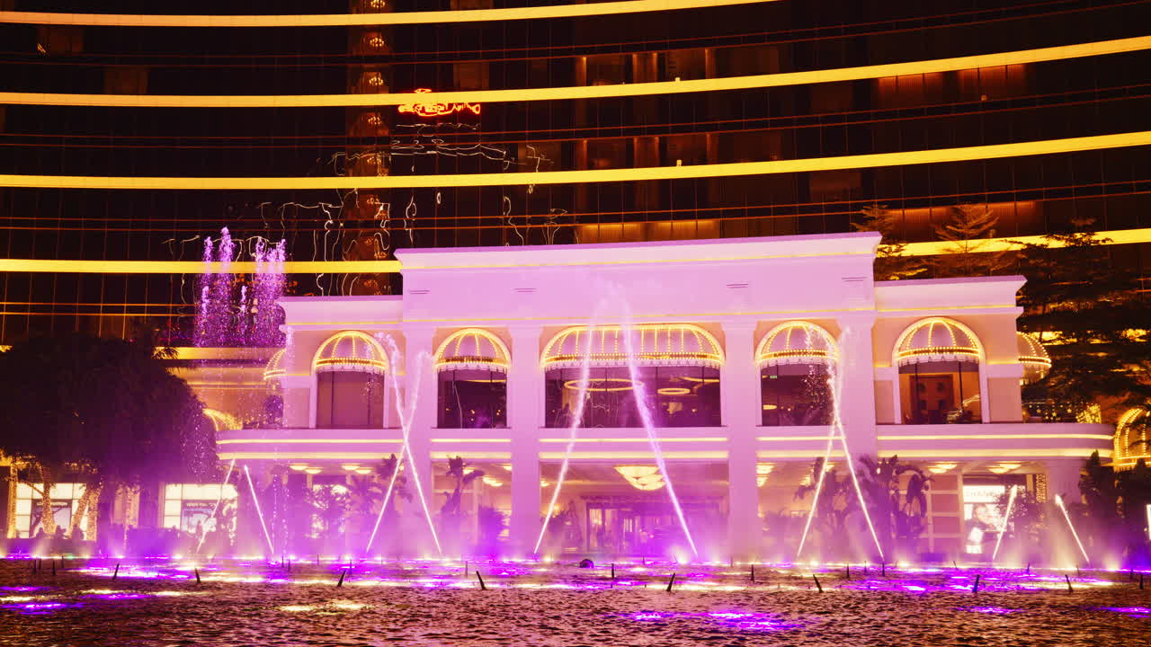 Vibrant Water Fountain Light Show at Night in Front of a Building