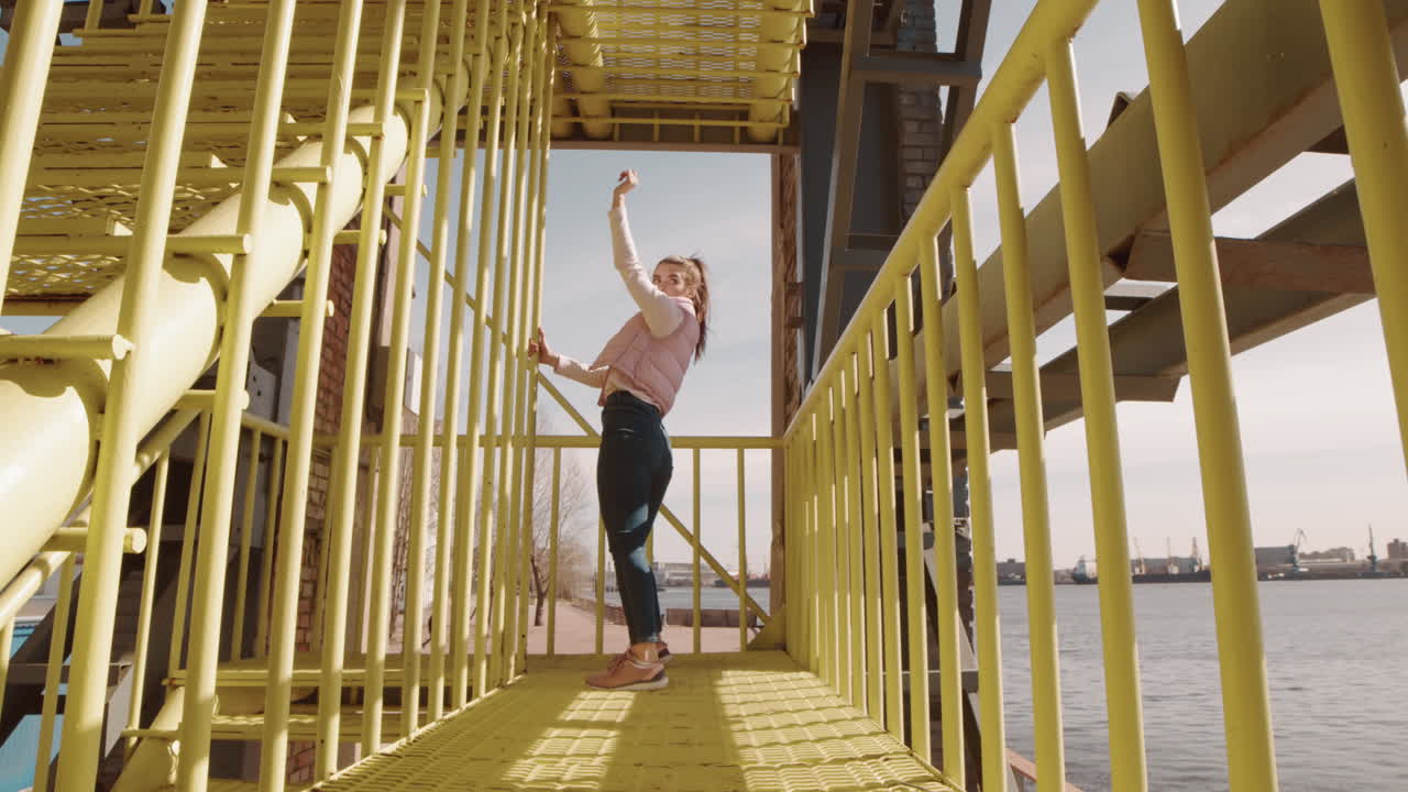 Woman Dancing on Industrial Stairwell Outdoors