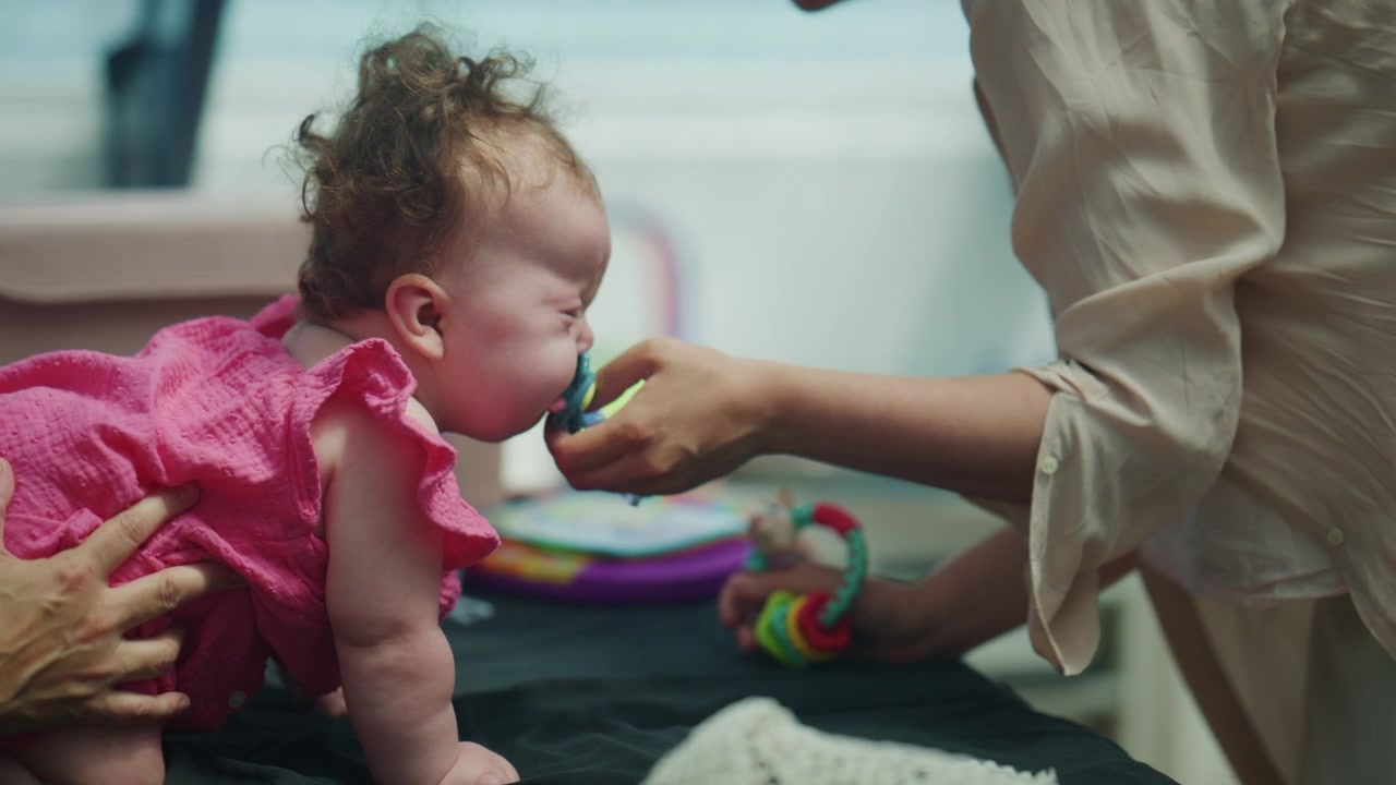 Vista trasera de un bebé practicando el tiempo boca abajo y ejercicios de movilidad asistida con cuidadores, promoviendo la fuerza del cuello, el control postural y el desarrollo físico en la primera infancia.