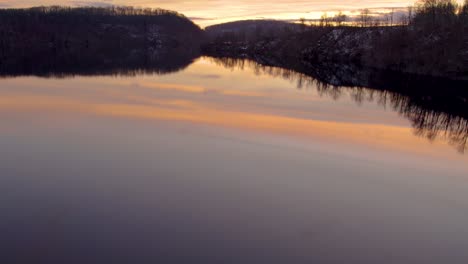 Aguas-Tranquilas-Del-Lago-Con-Reflejo-De-La-Puesta-De-Sol-En-Harz,-Alemania---Disparo-Aéreo-De-Drones