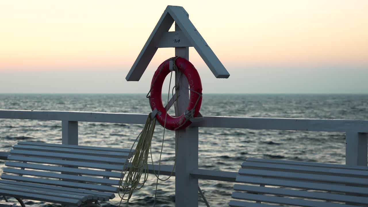 Salvagente su un molo di legno all'alba. L'ora d'oro sulla costa baltica polacca