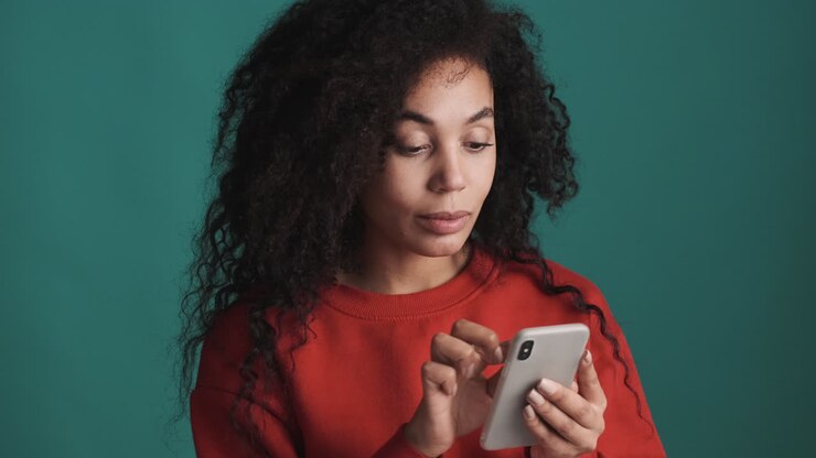 Donna afroamericana che usa lo smartphone su sfondo blu