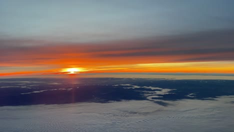vista aérea de un amanecer sobre alemania volando hacia el sur cerca de frankfurt en un frío día de invierno con un intenso cielo naranja sobre valles neblinosos