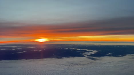 aerial view of a dawn over germany flying southward near frankfurt in a cold winter day with an intense orange sky over foggy valleys