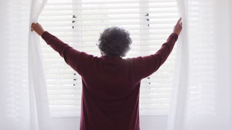 Glückliche-ältere-Afroamerikanische-Frau,-Die-Vorhänge-Im-Schlafzimmer-Weitet