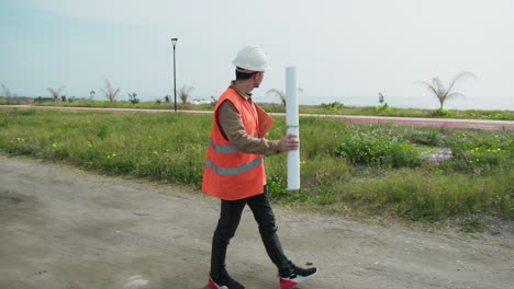architect walking on the construction site with the map in his hands