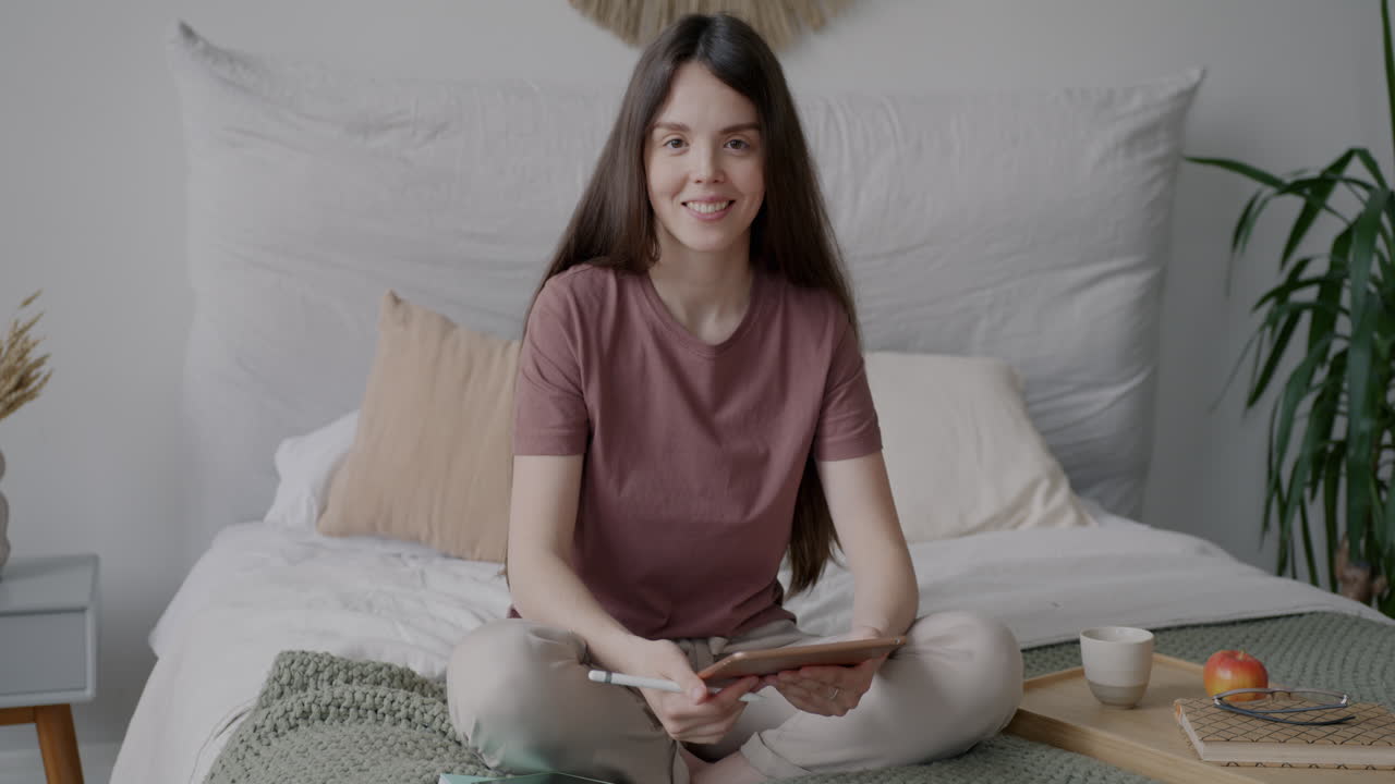 Woman working on a tablet in her bedroom