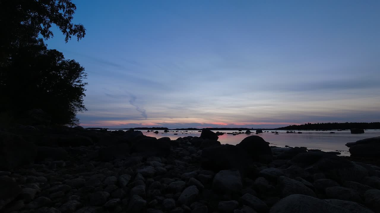 岩場のビーチで美しい夕焼けからブルーアワーへの移り変わり。