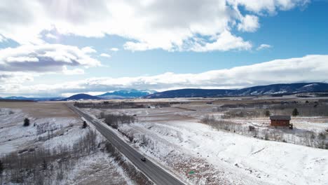 Drone-shot-of-a-remote-highway-with-some-small-homes-on-the-road-side