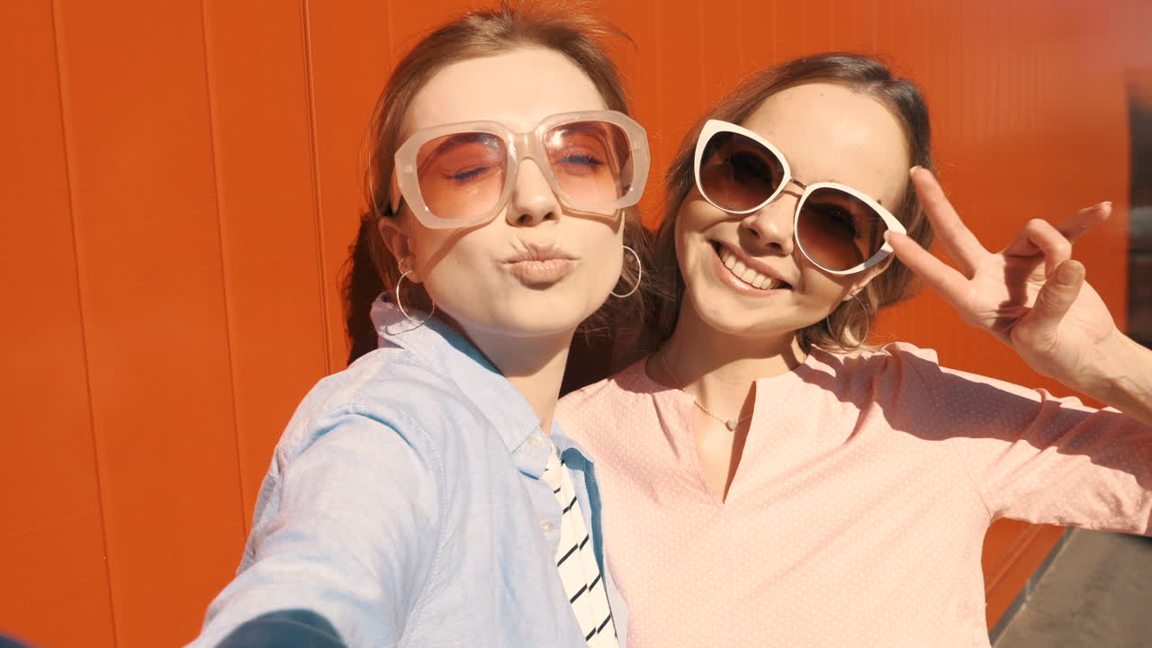 두 명의 행복한 여성들이 셀피를 찍고 있습니다.